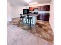 Kitchen with dark wood cabinets, island with bar seating and appliances at 2089 Belmont Cir, Conyers, GA 30012