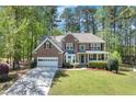 Charming two-story brick home with a well-manicured lawn, attached garage, and inviting front porch at 3918 Windgrove Xing, Suwanee, GA 30024