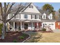 Inviting two-story home with a covered front porch and three-car garage, enhanced by mature trees at 6236 Benbrooke Nw Dr, Acworth, GA 30101
