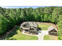 Beautifully landscaped two-story home with detached garage on a large lot surrounded by lush greenery at 105 Chantilly Ln, Fayetteville, GA 30215