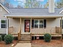 Inviting front porch with wood railing, stairs, and decorative plants leading to the entrance of the home at 162 Brookhaven Way, Rockmart, GA 30153