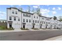 Attractive row of townhomes with white facades, dark roofs, garages, and well-maintained landscaping at 3170 Washburn Sw St, Atlanta, GA 30354
