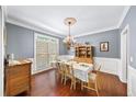 Bright dining room with hardwood floors, large window, and chandelier over the dining table at 3465 Summit Trl, Cumming, GA 30041