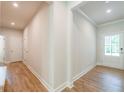 Hallway with wood-look floors leading to various rooms and featuring white trim and neutral paint at 3981 Adler Cir, Buford, GA 30519
