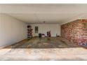 Spacious covered carport with storage shelving, brick accent wall and access to backyard at 4048 Suzanne Ln, Duluth, GA 30096