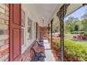 Inviting front porch with bench seating, classic brickwork, and garden views at 4048 Suzanne Ln, Duluth, GA 30096