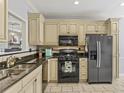 Well-equipped kitchen features black appliances, granite countertops, and tile flooring at 7 Nesbit Pl, Alpharetta, GA 30022