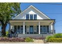 Inviting home featuring a cozy covered porch with black railing, a porch swing, and a well-manicured lawn at 1076 Manigault Se St, Atlanta, GA 30316