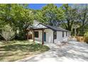 Stylish home showing front exterior, a long driveway, fresh lawn, and black window trim at 1189 Gardenia Nw St, Atlanta, GA 30314
