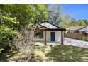 Charming home featuring a blue front door, wooden posts, manicured lawn, and a long driveway at 1189 Gardenia Nw St, Atlanta, GA 30314