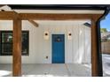 Home featuring a blue front door, wooden posts, wall lights, and black window trim at 1189 Gardenia Nw St, Atlanta, GA 30314