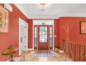 Inviting foyer with decorative glass front door, light wood flooring, and coat rack at 20 Balfour Dr, Covington, GA 30014