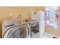 Laundry room with front load washer and dryer and view to outside at 20 Balfour Dr, Covington, GA 30014
