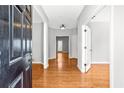 Bright foyer with hardwood floors and natural light streaming in from the doorway at the end of the hall at 4606 Liberty Square Dr, Acworth, GA 30101