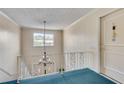 Hallway with teal carpet, white walls, and ornate chandelier, leading to unit 21 at 6851 Roswell Rd # A21, Sandy Springs, GA 30328