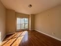 Empty bedroom with hardwood floors, a large window, and neutral wall color at 6893 Spring Valley Ct, Douglasville, GA 30135