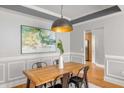 Dining room with wooden table, stylish pendant light, and wainscoting details at 1261 Ashford Creek Ne Park, Brookhaven, GA 30319