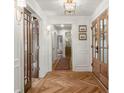Elegant foyer showcasing beautiful herringbone wood floors, white wainscoting, and wood trim at 5641 Roberts Dr, Dunwoody, GA 30338
