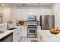 Modern kitchen boasts stainless steel appliances, white cabinetry, and marble countertops at 1253 Caroline Ne St # 229, Atlanta, GA 30307