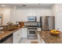 Bright kitchen featuring stainless steel appliances, granite counters, and white cabinets at 1253 Caroline Ne St # 229, Atlanta, GA 30307