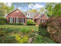 Brick home with beautiful landscaping featuring lush greenery and blooming plants at 1410 Daley Ridge Ct, Lawrenceville, GA 30045