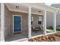 Inviting front porch features brick accents, stylish seating, and a vibrant blue front door at 328 Foxglove Way, Mcdonough, GA 30253