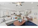 Bright living room featuring a modern ceiling fan, hardwood floors, and an open layout to the kitchen at 328 Foxglove Way, Mcdonough, GA 30253