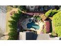Aerial view of an in-ground pool surrounded by lush landscaping, seating, and a pergola at 5473 Heyward Square Pl, Marietta, GA 30068