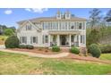 Charming two-story home with a symmetrical facade, dormer windows, a welcoming front porch, and mature landscaping at 603 Redcoat Cir, Canton, GA 30114