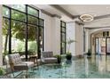 Bright lobby features a sleek modern design with stylish seating and large windows overlooking lush landscaping at 795 Hammond Dr # 806, Sandy Springs, GA 30328