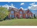 Beautiful two-story brick home with a lush green lawn and professional landscaping under a bright sky at 866 Coopers Ridge Sw Path, Grayson, GA 30017