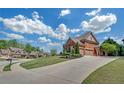 Brick home with a long driveway, well-kept lawn, and beautiful landscaping on a sunny day at 866 Coopers Ridge Sw Path, Grayson, GA 30017