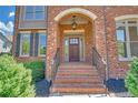 Close-up of the arched front porch with brick steps and an elegant wood door at 866 Coopers Ridge Sw Path, Grayson, GA 30017