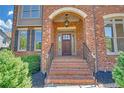 Covered front entry featuring a beautiful solid door, brick steps, and wrought iron railings at 866 Coopers Ridge Sw Path, Grayson, GA 30017