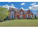 Elegant brick home with a manicured lawn, mature trees, and classic architectural details at 866 Coopers Ridge Sw Path, Grayson, GA 30017