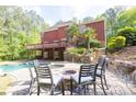 Luxurious backyard with a pool, hot tub, fire pit area, and lush greenery creating a private oasis at 1459 Harris Rd, Lawrenceville, GA 30043