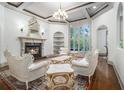 Elegant living room with a fireplace, ornate furniture, detailed trim, and a large arched window offering natural light at 3574 N Druid Hills Rd, Decatur, GA 30033