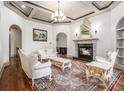 Elegant living room with fireplace, coffered ceilings, and ornate furniture at 3574 N Druid Hills Rd, Decatur, GA 30033