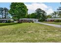 Traditional brick ranch with an expansive front yard and mature trees at 241 Burke Cir, Mcdonough, GA 30253