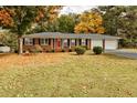 Charming brick home featuring a well-manicured lawn with colorful fall foliage at 241 Burke Cir, Mcdonough, GA 30253