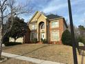 Traditional two-story brick home featuring a manicured lawn and a welcoming arched entryway at 3270 Moon Beam Ct, Snellville, GA 30039