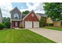 Inviting exterior showcasing a well-maintained lawn and brick details on the two-story home at 1265 Birchwood Ln, Roswell, GA 30076