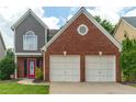 Beautiful front view of the two-story home featuring a brick facade and a two-car garage at 1265 Birchwood Ln, Roswell, GA 30076
