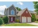 Attractive two-story home with a manicured lawn, gray and brick facade, and a two-car garage at 1265 Birchwood Ln, Roswell, GA 30076