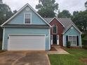 Charming home with a light blue exterior, brick accents, a well-manicured lawn and a two-car garage at 263 Northwind Dr, Stockbridge, GA 30281