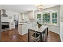 Modern eat-in kitchen with white cabinetry, stainless steel appliances, granite countertops, and a cozy breakfast nook at 3380 E Wood Valley Rd, Atlanta, GA 30327