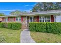Close-up of a charming brick home with decorative window shutters and a paved walkway at 4164 Weston Dr, Powder Springs, GA 30127