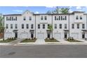 Row of modern townhomes with white facades, black accents, garages, and well-maintained landscaping at 148 Werner Brook Sw Way, Atlanta, GA 30354