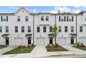 Exterior view of modern townhouses featuring white siding, black trim, and driveways at 148 Werner Brook Sw Way, Atlanta, GA 30354