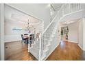 Inviting foyer featuring hardwood floors, a staircase, and an elegant chandelier, with dining room view at 374 Meadowmeade Cv, Lawrenceville, GA 30043